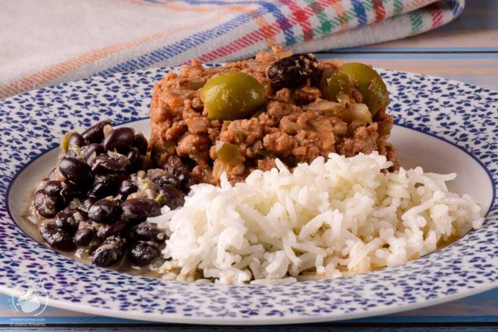 Plate of white rice, black beans and picadillo