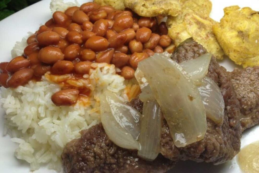 White rice, pink beans and beef steak with onions