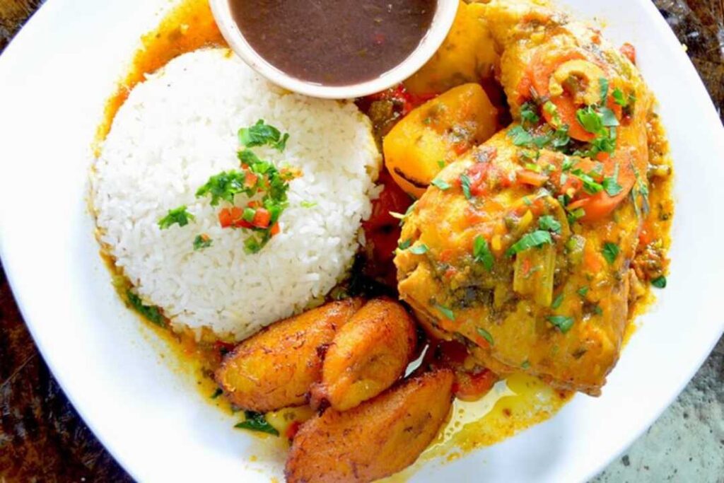 White rice and braised chicken in a plate with sweet plantains