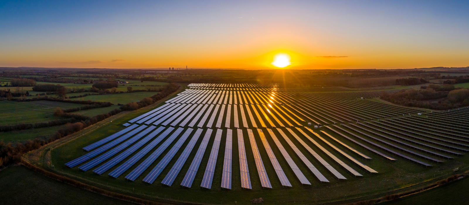 panoramic view of solar field with sun coming up