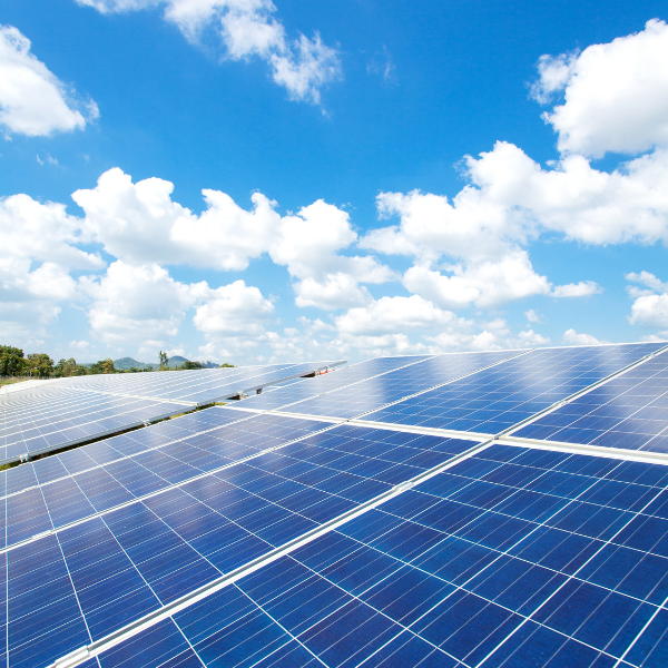 Solar panels with bright blue sky and clouds